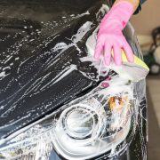close up image of someone washing the front side of a car